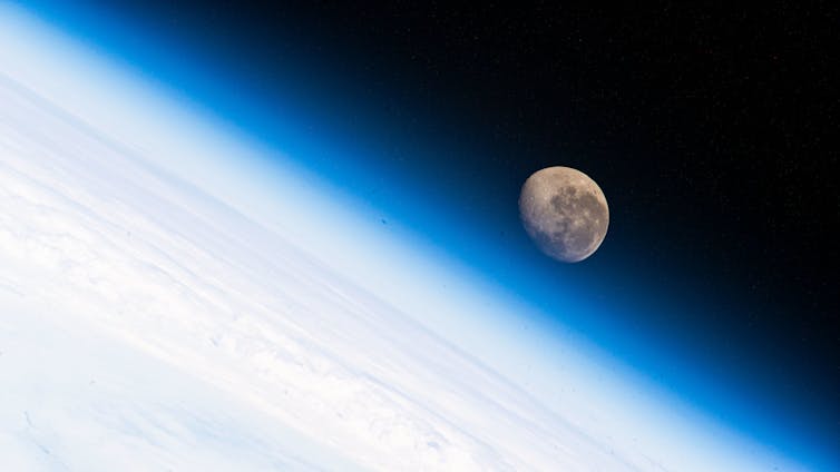 A photo of the moon over the Earth's horizon taken from the International Space Station