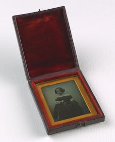 A black and white photograph in a velvet lined box.