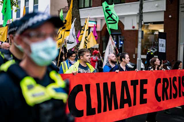Protestors carry a banner reading 'CLIMATE CRISIS'