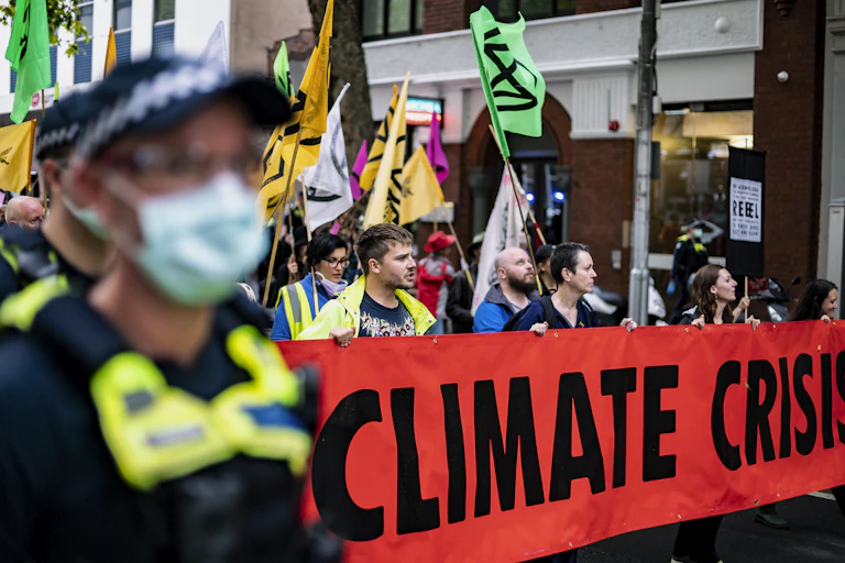 Protestors carry a banner reading 'CLIMATE CRISIS'