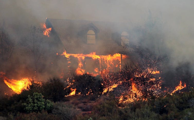 A home catches fire a wildfire moves through Lower Lake, California, in 2015
