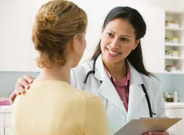A Latina physician talks to her patient.