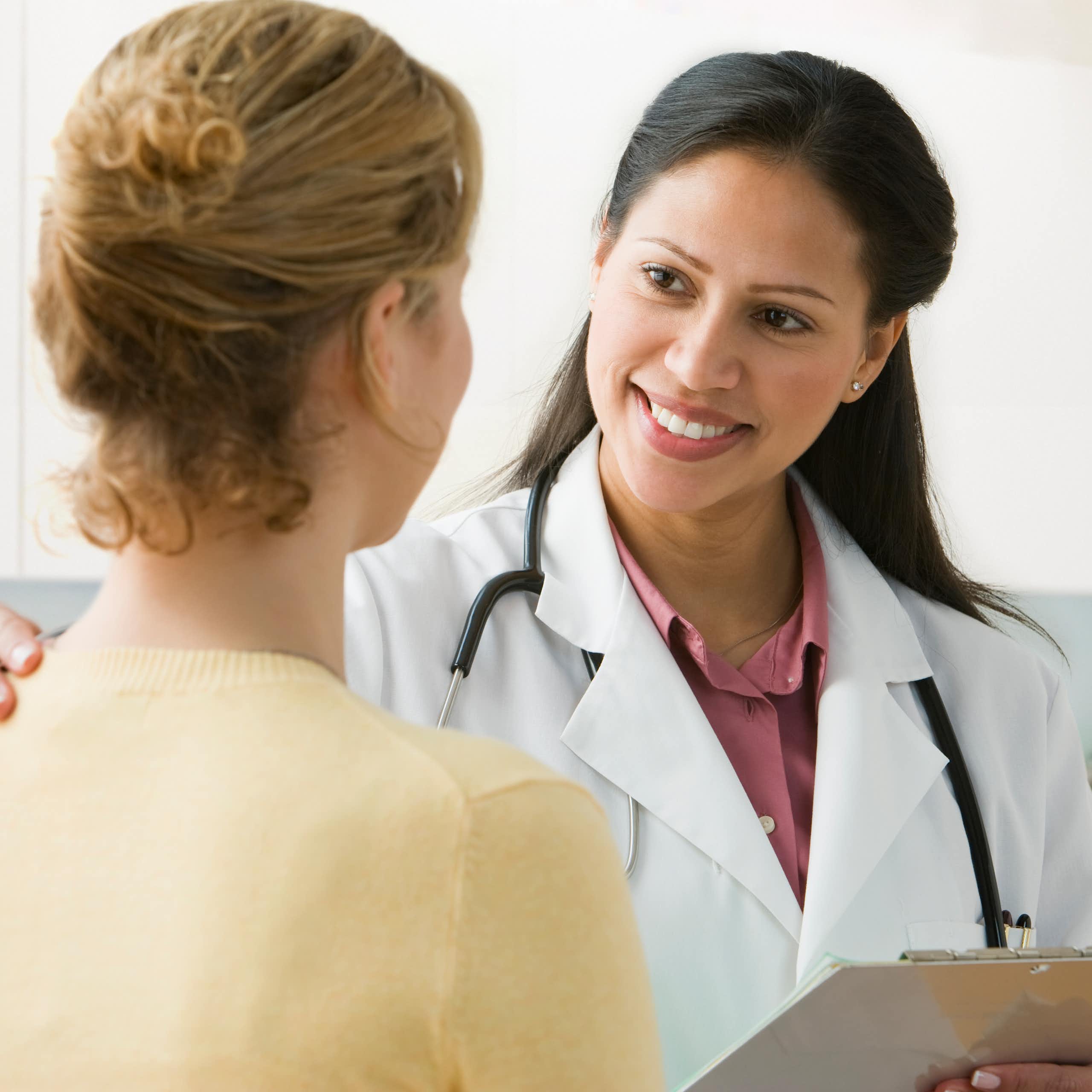A Latina physician talks to her patient.