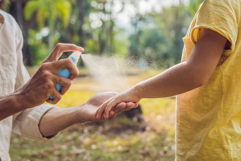 woman sprays child with repellent