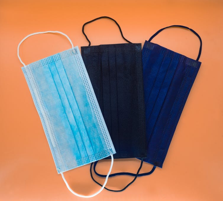 Masques bleu clair, noir et bleu foncé déposés sur une table