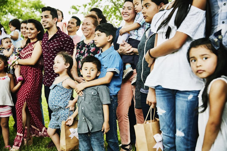 A multigenerational Hispanic family gathered for a family portrait.