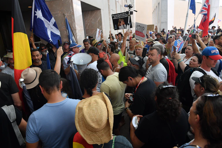 Demonstrators protesting for freedom gather outside Parliament House in Canberra.