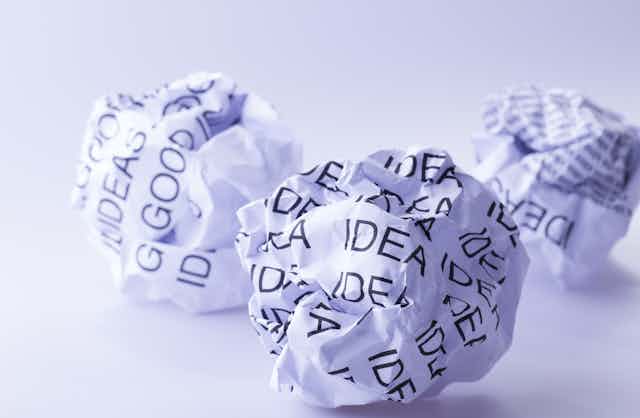 Scrunched up balls of paper with words 'good ideas' printed on them