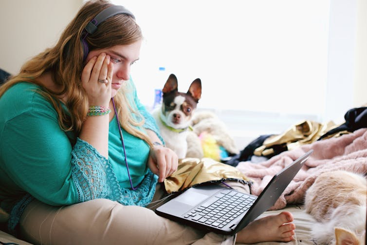 Young woman with autism and other learning disabilities using laptop for remote learning.