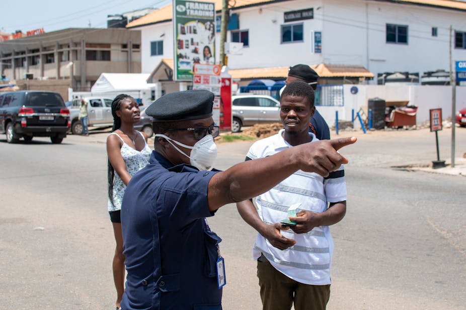 A policeman directing a man and a woman on a street