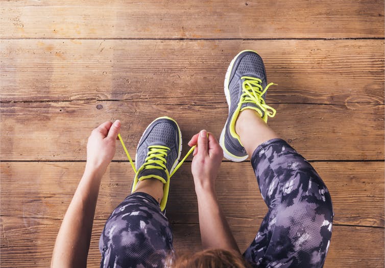 A woman ties up her trainers.