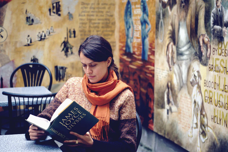 Woman reads Ulysses in cafe.