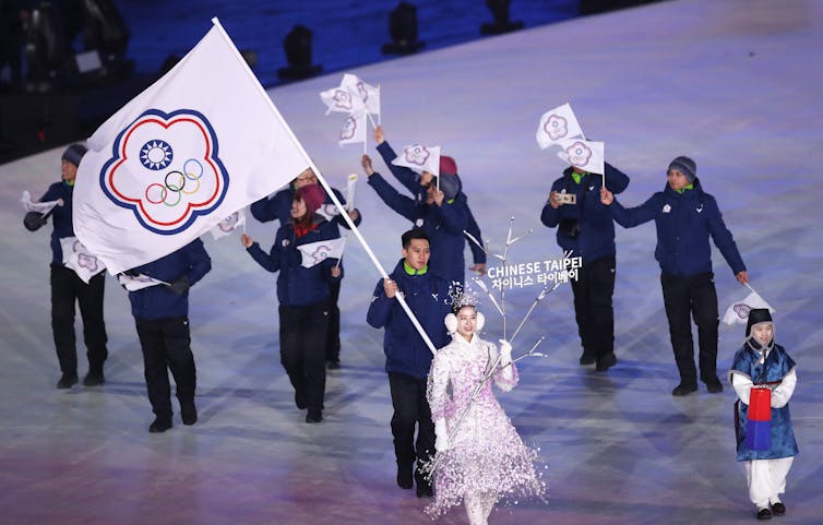 A flag-bearer at the 2018 Winter Olympic Games holds aloft the emblem of the Chinese Taipei team.