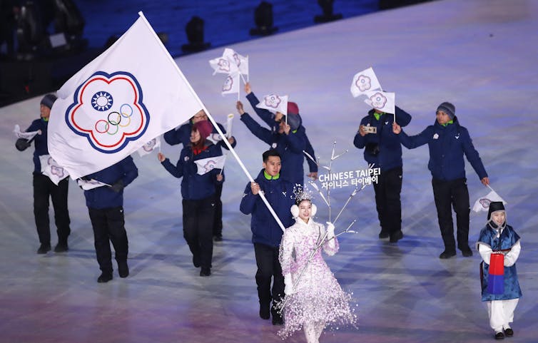 A flag-bearer at the 2018 Beijing Winter Olympic Games holds aloft the emblem of the Chinese Taipei team.