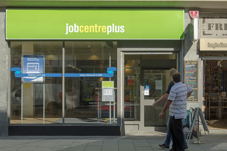 Two men walking in front of a JobCentrePlus shopfront