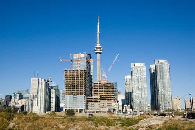 construction of high rises with toronto's cn tower in the background