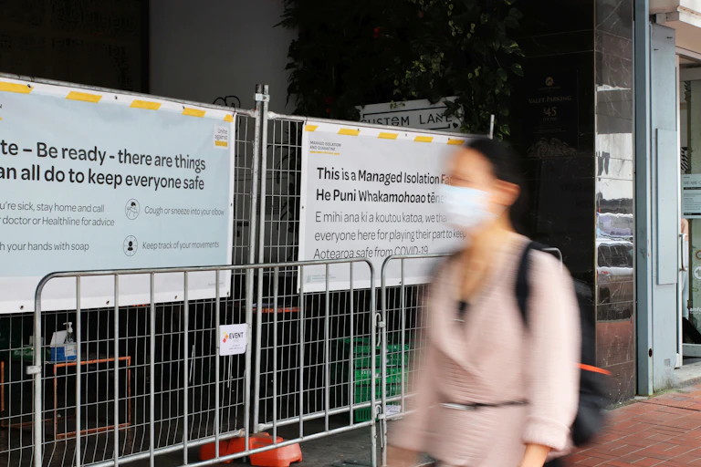 Woman walking past a managed isolation and quarantine hotel