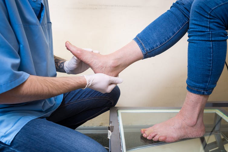 Doctor looking at patient's flat feet