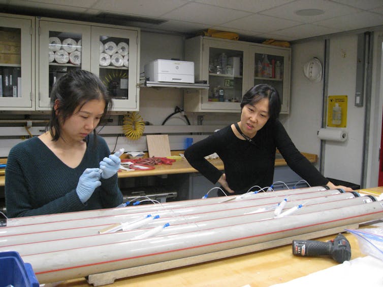 Two researchers working on sediment cores.