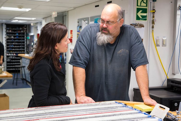 Palaeontologist Laia Alegret (Spain) and co-chief scientist Gerald Dickens (US) discuss a sediment core at the sampling table during IODP Expedition 371.