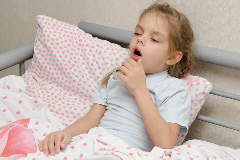 Child in bed coughing.