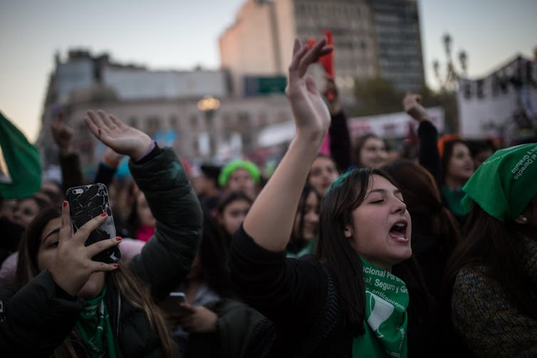 Demonstrators to make abortion legal in Argentina with arms raised.
