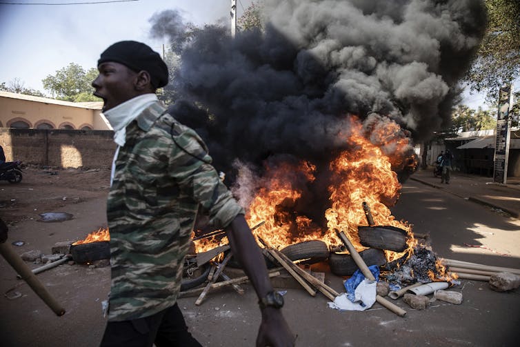 Un homme passe devant une scène de destruction