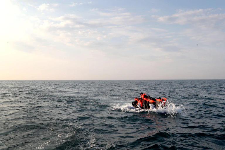 A group of migrants crossing the Channel in a small boat headed in the direction of Dover, Kent.