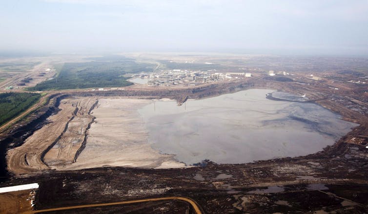 Aerial photograph of a large rectangular lake of mining waste.