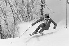 A black and white photo of a man skiing.