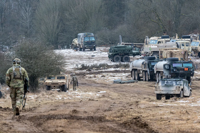 A soldier is shown next to a series of U.S. army equipment, including tanks