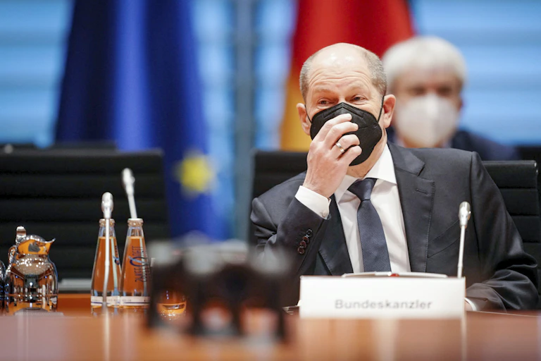 man wearing suit and touching mask