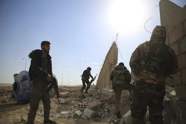Kurdish-led Syrian Democratic Forces fighters take their positions at the defense wall of Gweiran prison.