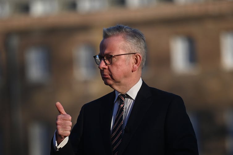 Michael Gove gives a thumbs up with a determined look on his face