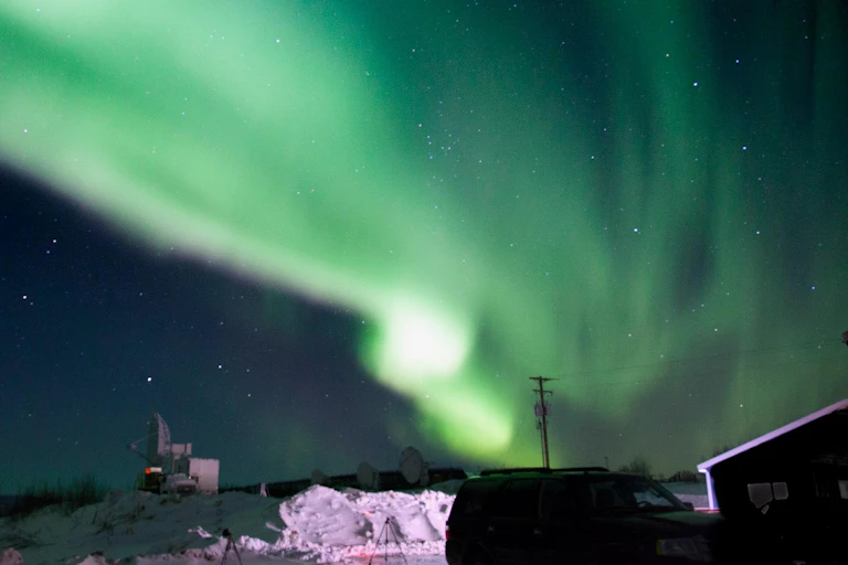 A green aurora reaching down to the Earth's surface.