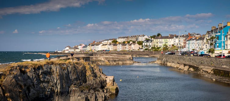 A view of the seafront in a small Northern Irish town, with the sea beyond.