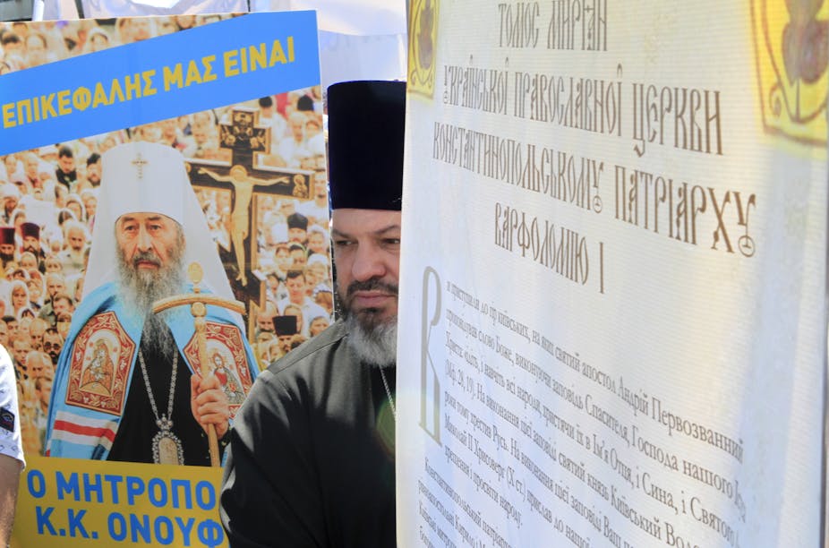 An Orthodox priest in black attire at a protest rally in Kyiv, Ukraine.