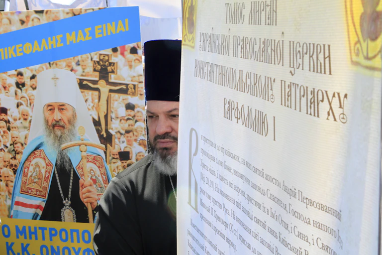 An Orthodox priest in black attire at a protest rally in Kyiv, Ukraine.