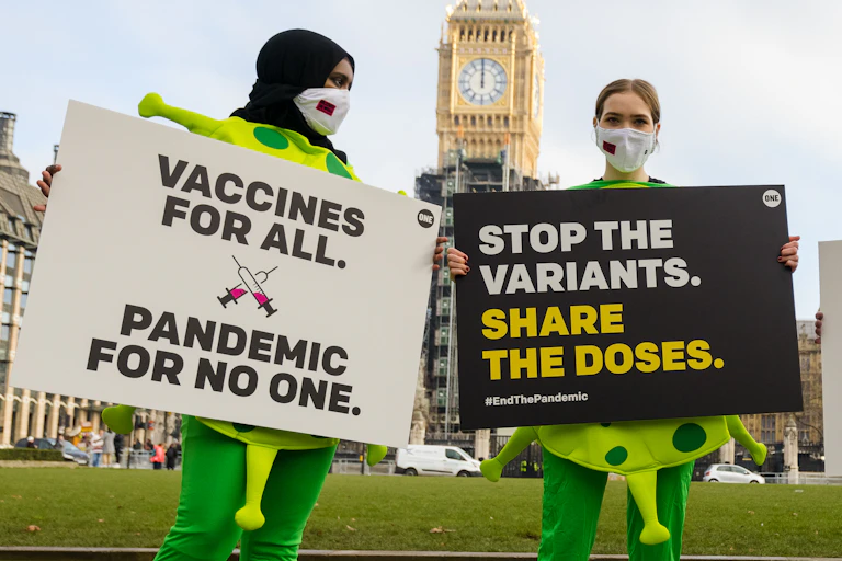 Campaigners outside of the UK parliament asking for vaccines to be shared worldwide