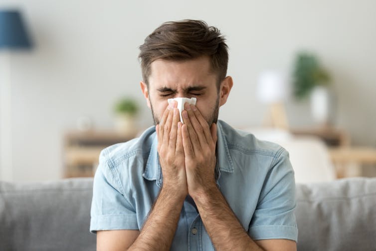 A man with COVID sneezing