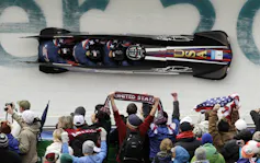 A team of bobsled racers going around a corner.