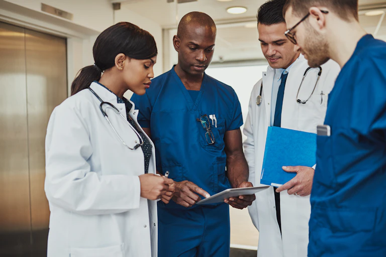 A group of doctor seen discussing a chart.