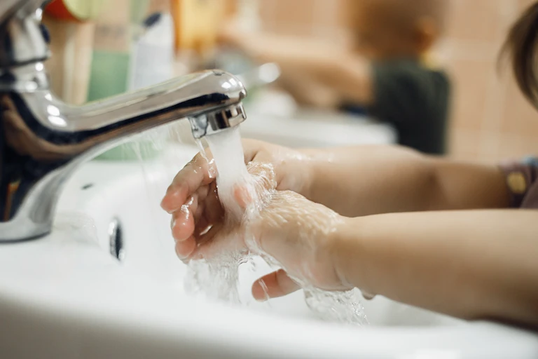 Toddler washing hands.