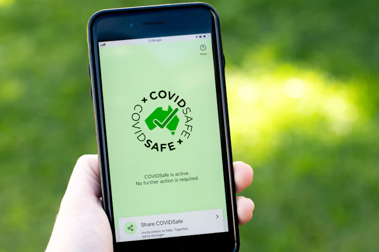 Person holding smartphone with CovidSafe app on screen