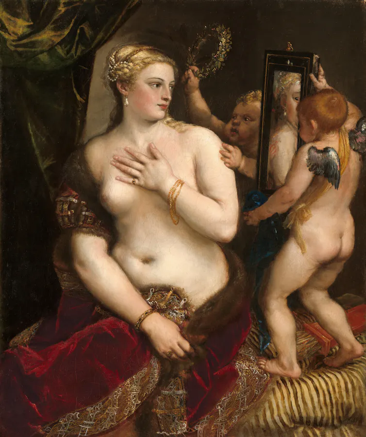 A naked Venus looks in a mirror held up by cherubs