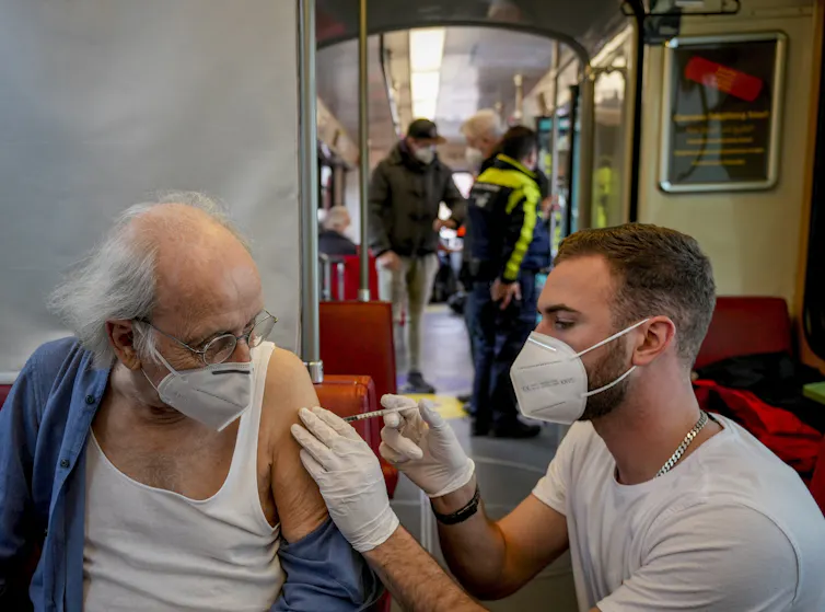 Person receives COVID vaccine on the 'vaccination express' tram in Germany