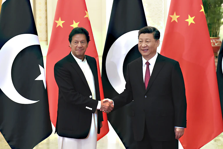 Pakistan prime minister Imran Khan shakes hands with Chinese president Xi Jinping in front of Chinese and Pakistani flags
