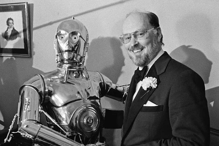 John Williams, right, shakes hands with Star Wars character C-3PO