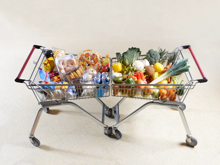 Deux caddies alignés, l’un rempli de fruits et légumes, l’autre de sucreries et d’aliments riches en graisses