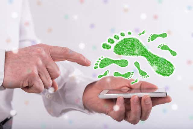 finger points to smart phone below green footprints